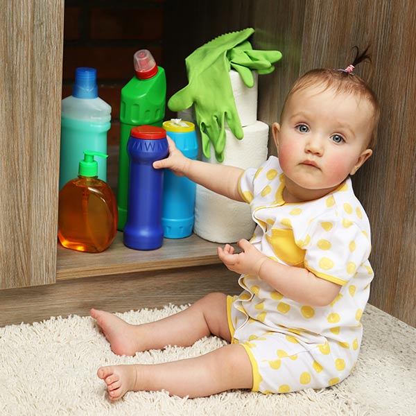 Baby with kitchen cleaning products