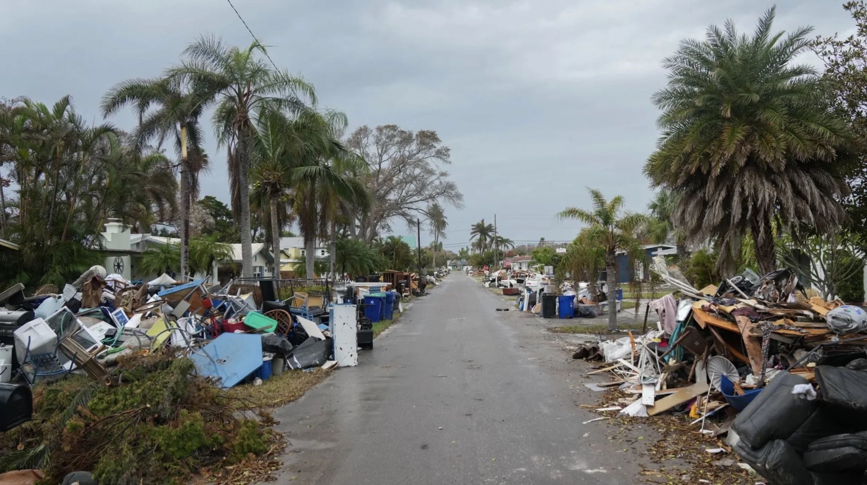 Debris litters both sides of a St. Petersburg, FL street in the aftermath of hurricanes in 2024.