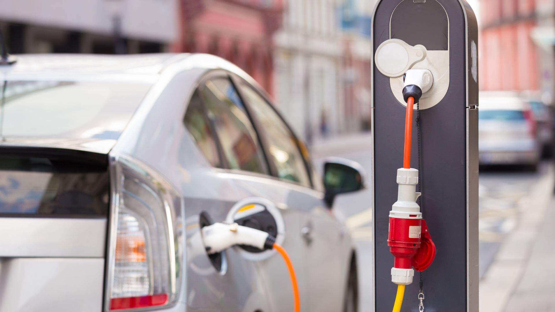 An electric car charging at a roadside charging station