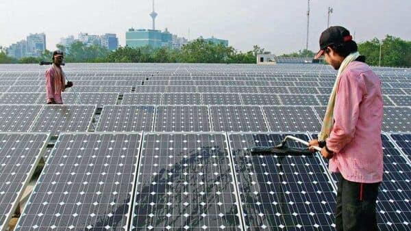 Two people work on an array of solar panels