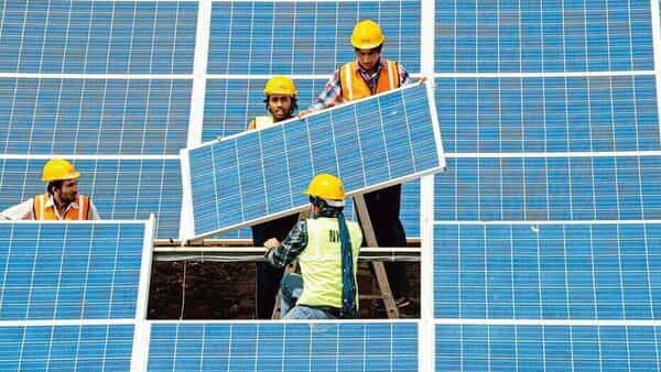 Workers install solar panels