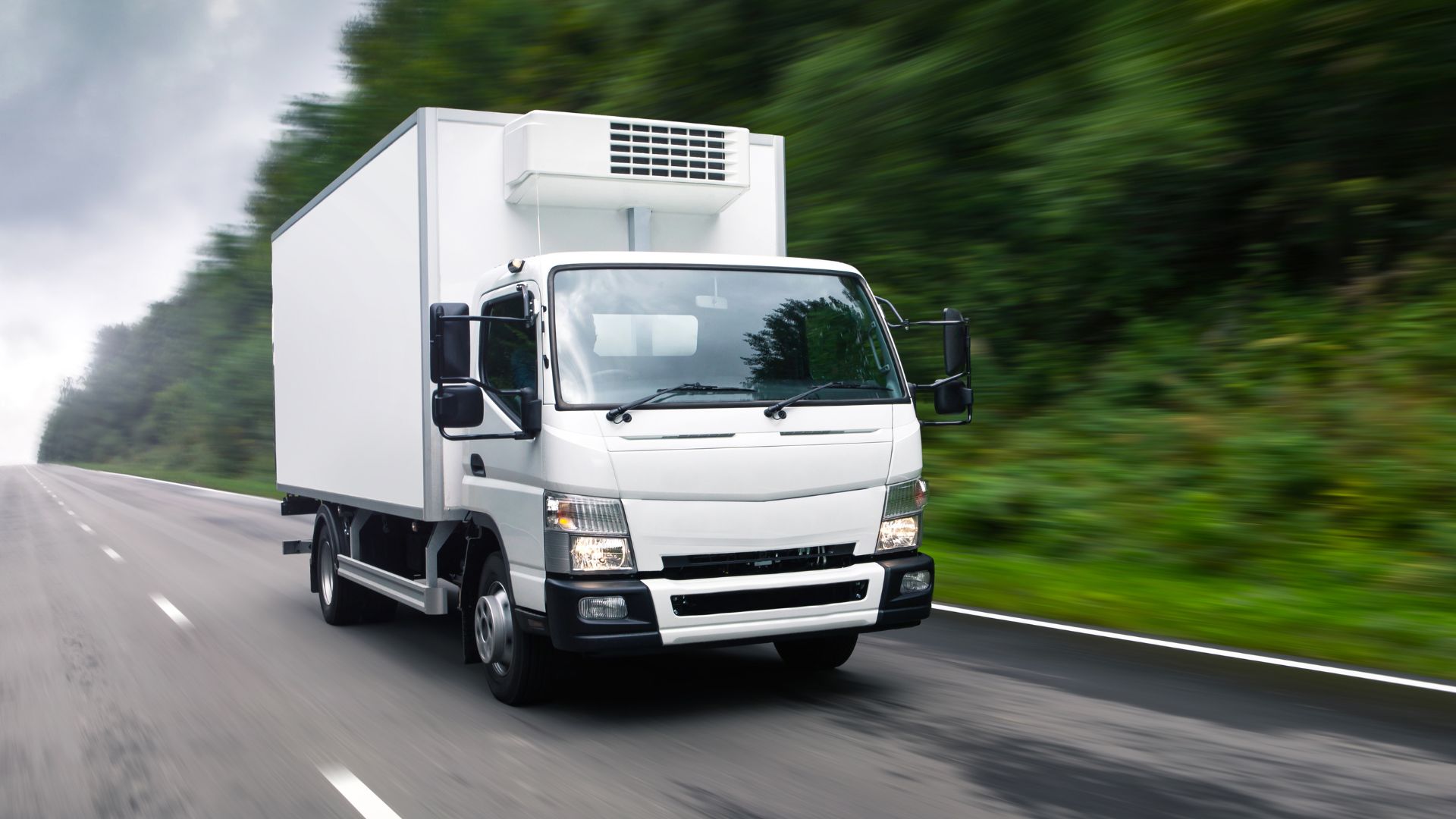 An electric delivery truck driving down a road