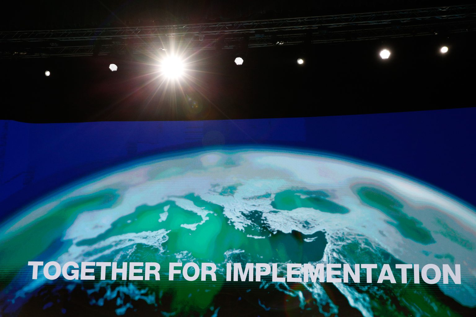 A screen reading &quot;Together for implementation&quot; imposed on a globe