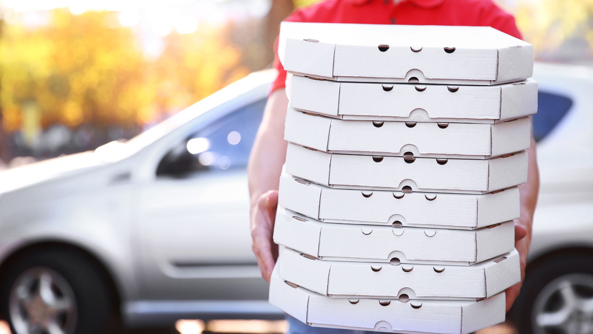 Someone holding, honestly, too many pizza boxes