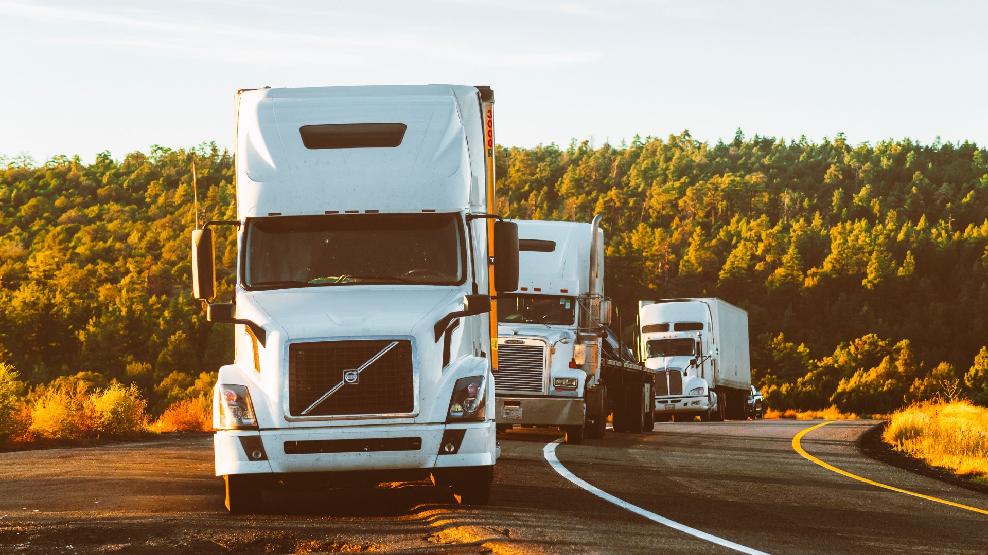 Three semi-trucks cruising down the road