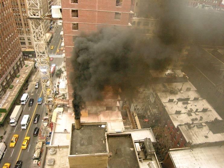 Black smoke billows out of a building's chimney in New York City