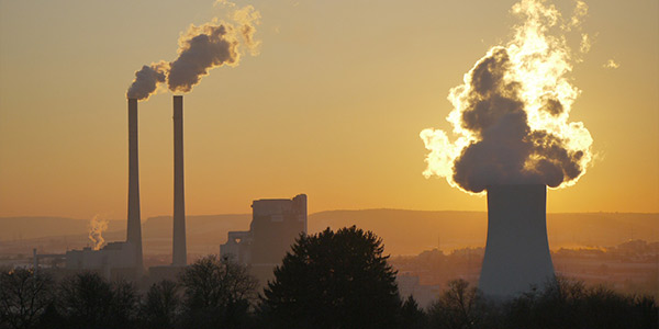 Coal power plant with smoke stacks at sunset