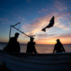 Fishermen on boat at sunrise