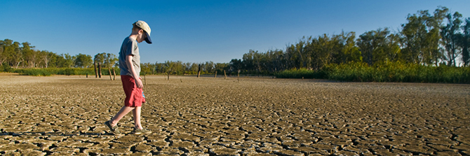 boy walking on a dry lake bed