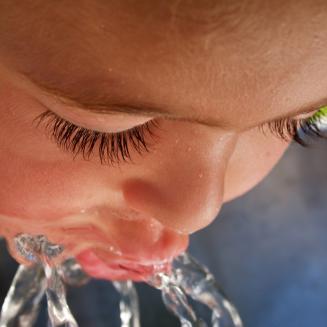 Close view of child drinking from water fountain