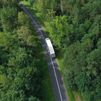 Aerial view of truck on highway through woods