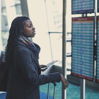 Woman at the airport looking at the departures board
