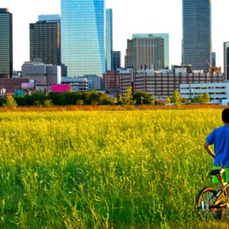 Boy with bike in front of Houston, TX skyline