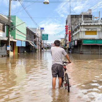 Man walking with bike in flood