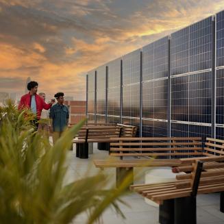 Young people on a rooftop examining solar panels