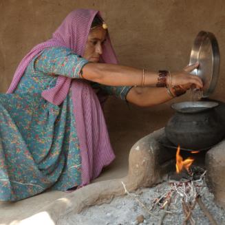 Indian woman using cook stove.