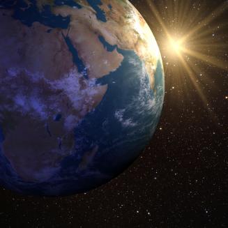Earth in space with the Sun rising over the horizon