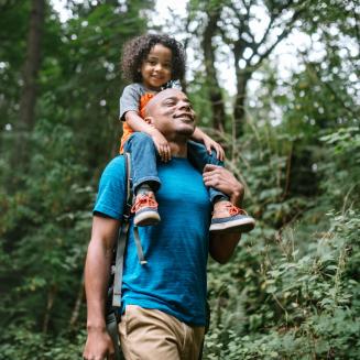 Man with child on his shoulders, both smiling