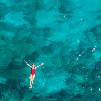 Woman swimming in the ocean, shot from above