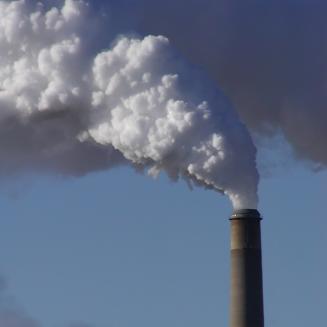 A smokestack with white smoke billowing out of it