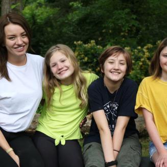 Keena Mullins  poses for a photo seated with her three smiling children