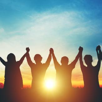 People with joined, raised hands