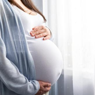 A pregnant woman cradles her belly