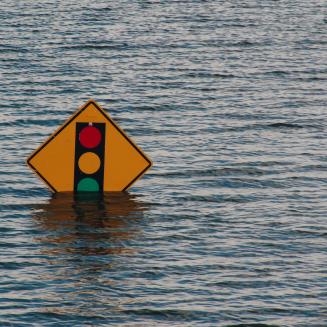 Road sign partially submerged in flood waters