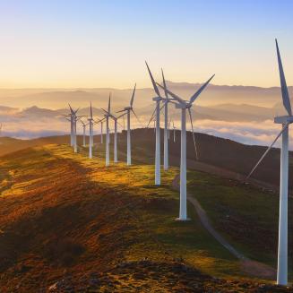 A row of wind turbines on a hillside