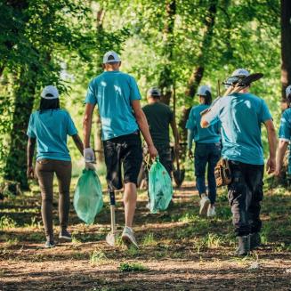 A group of young people picking up trash in a forest