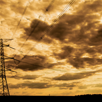 Powerlines against cloudy sky