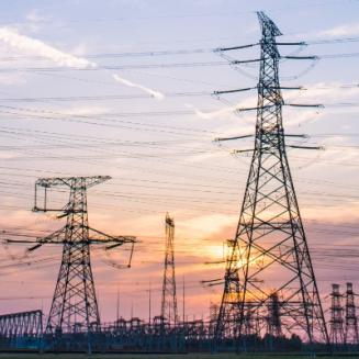 Panorama of powerlines against setting sun.