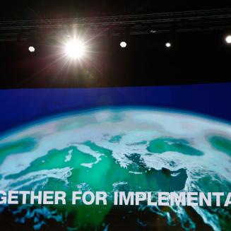 A screen reading "Together for implementation" imposed on a globe