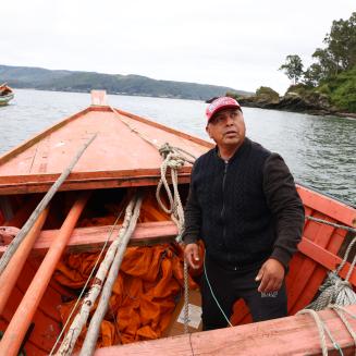 A fisherman sits in a boat on a river in Ecuador