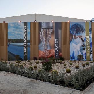 An exterior photo of COP27 buildings depicting vertical banners reading Adaptation, Decarbonization, Water, Science, and Agriculture & Food Systems