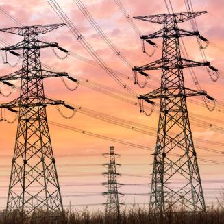 Transmission towers with lots of power lines running to them at dusk