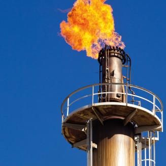 Methane flare on a smokestack