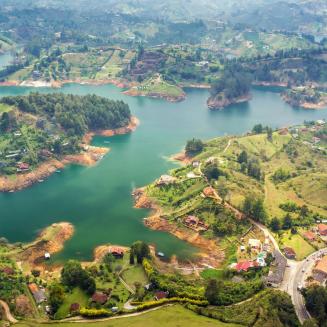 A high-up shot of a lake surrounded by lots of green hills