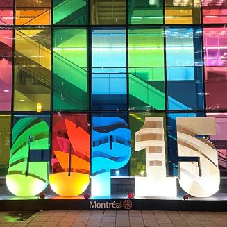 the scene outside of a convention center, with a colorful sculpture forming the words COP15.