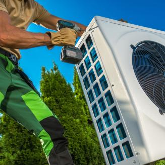 A muscular man installs a heat pump