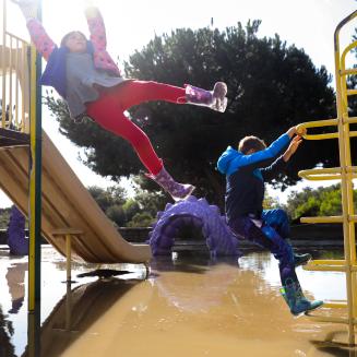Kids swinging and climbing in a flooded playground
