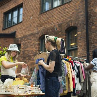 Three people thrift shopping outside