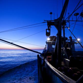 Fishing boat on the water with striking dark blue sky