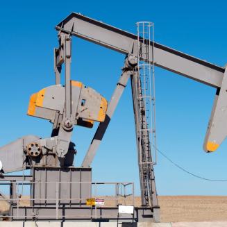 Closeup view of an oil well against a blue sky in the desert