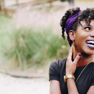 Black woman laughing in a park