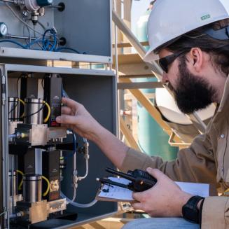 A researcher works with equipment as part of a field test of hydrogen quantification tech.