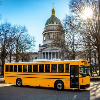 An electric school bus parked in front of the US Capitol