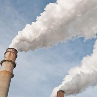 Smoke stacks billowing white smoke into the air