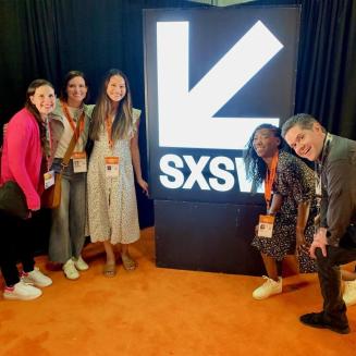 A group of five EDFers standing near a SXSW illuminated sign