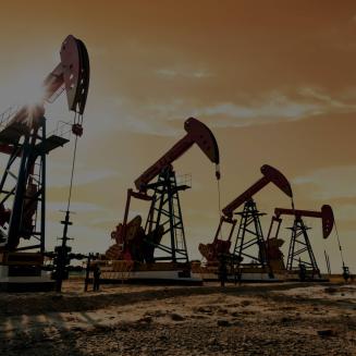 Oil wells in the desert against a yellow sky